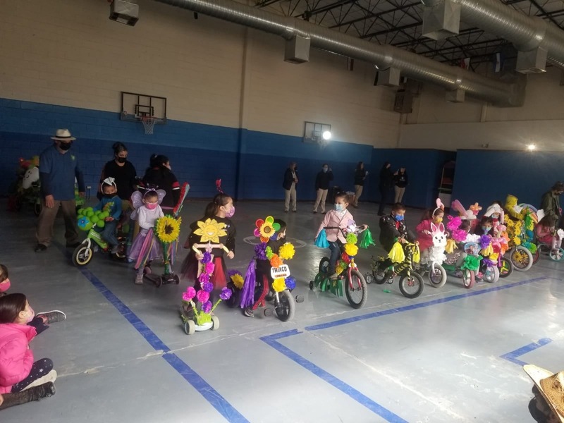 Desfile de triciclos decorados en el gimnasio