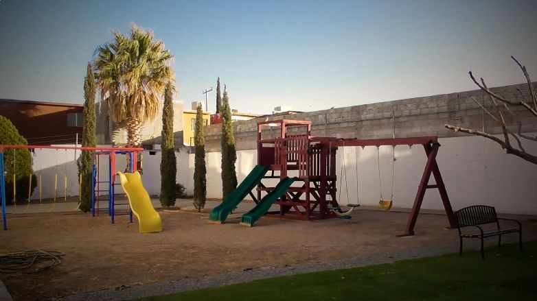 Área de juegos infantiles con resbaladillas y columpios